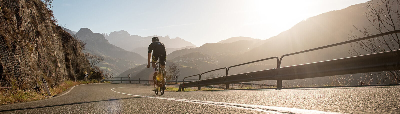 Man cycling on a road in the mountains